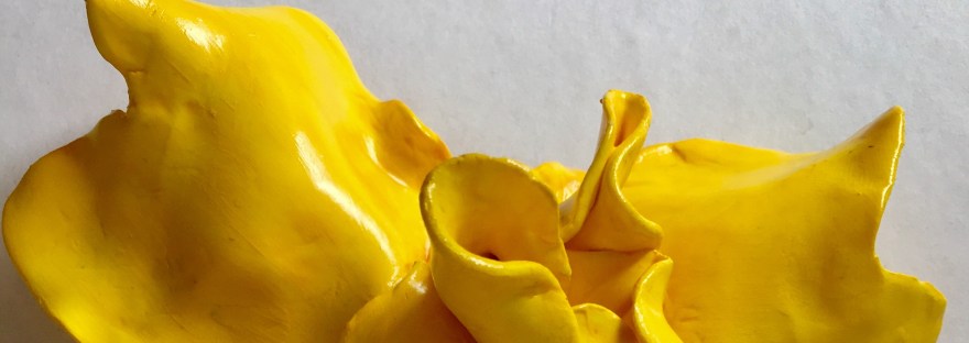 Iris 3, part of the series in the Iris collection. This small sculpture neatly fits in the palm of the hand and is very tactile. Painted yellow on fimo clay. The artist was inspired by a visit to Winterbourne House and Gardens in May 2019.